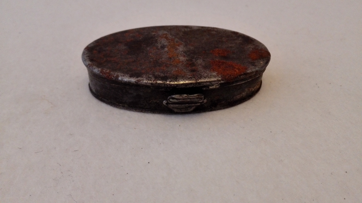Form: Oval, flat.
1 tobaksdaase av jern.

Oval, flat tobaksdaase av jern. 7,7 x 4,8 cm.

Kjøpt av landh. Theodor Lindstrøm, der har erhvervet ovennævnte gjenstande i Lærdal.