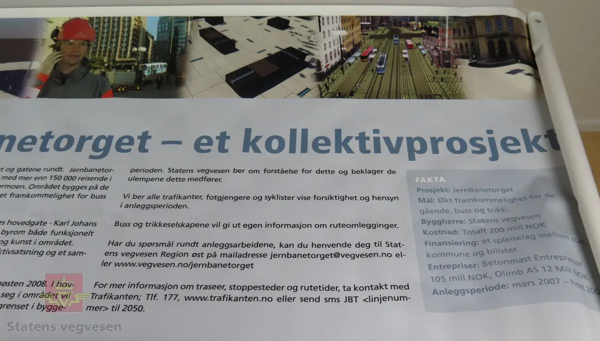 Rektangulær flerfarget plansje av plastlignende materiale, maljer i hvert hjørne. Tekst forteller om prosjektet med fornyelse av Jernbanetorget og gatene rundt.