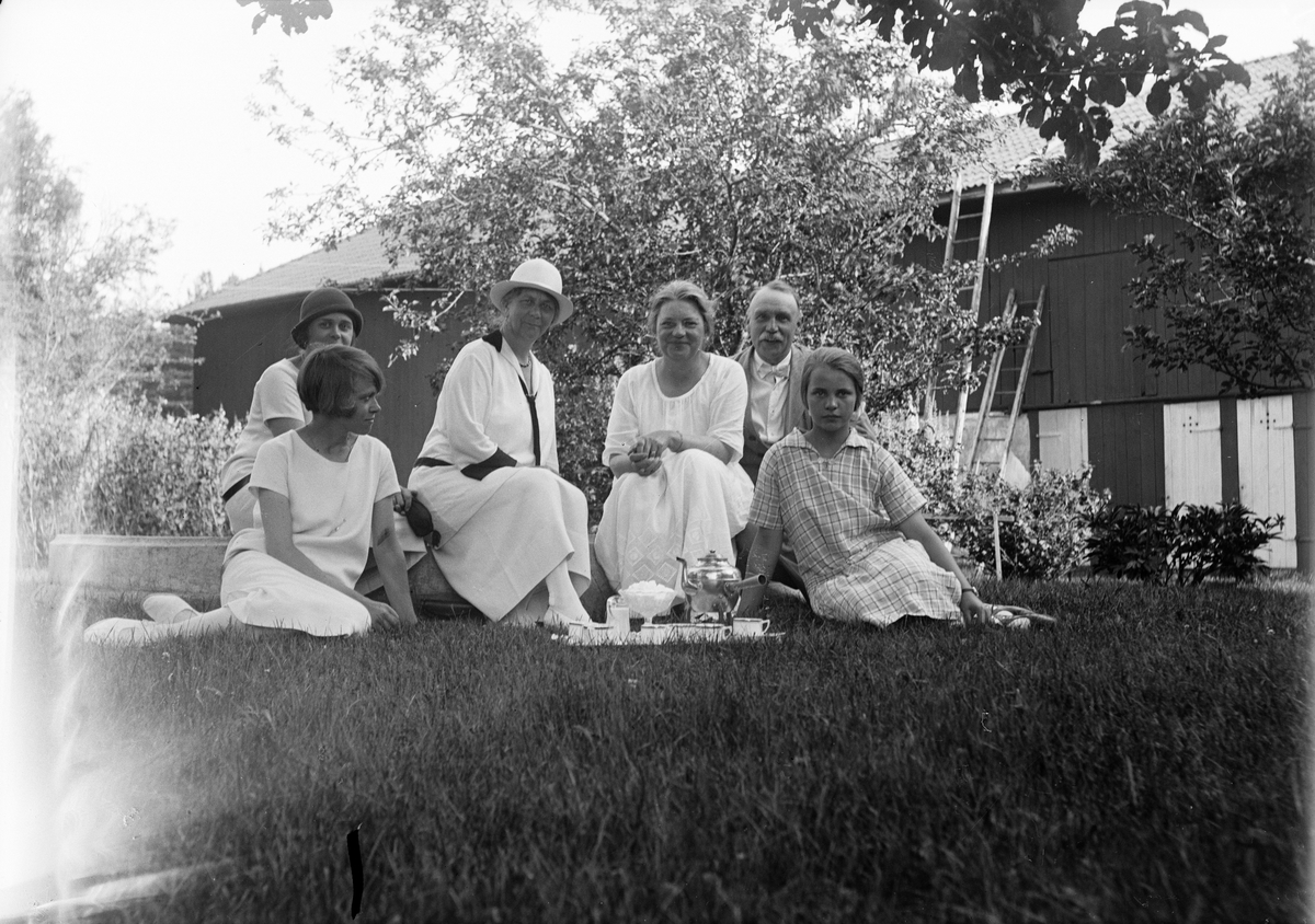 Christiane och Ruben Liljefors med vänner har kaffepaus på gräsmattan ute i trädgården, dottern Marit längst till höger, sannolikt i Sverige