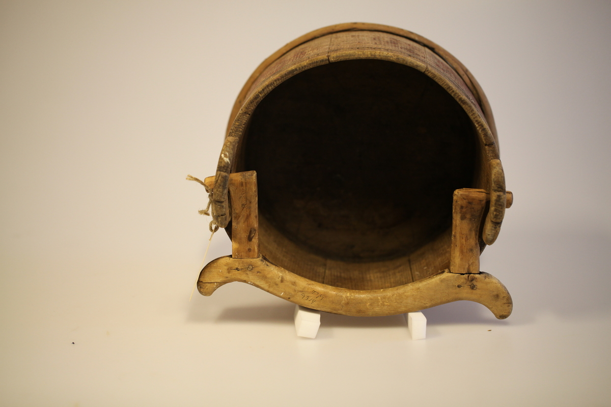 Lagget med 2 gjorder, men den øverste er borte. Bevegelig tverrhank med tretapper, to ører og innfelt bunn. Formen er rund, sylinderformet, uten lokk eller ben. Har vært påmalt rød farge. Brukt til melk.