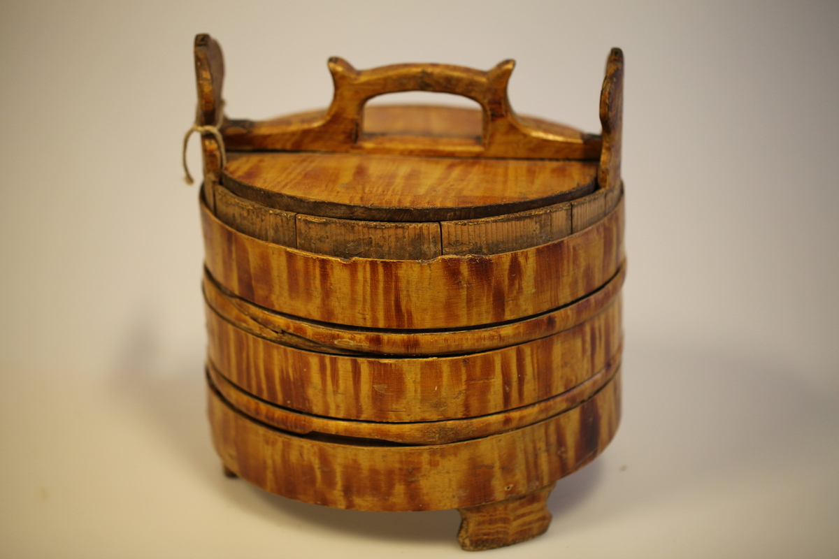 Lagging belagt med tette sveiperinger. Lokk, to ører  og tre bein. Formen er rund, lokk er nedfelt og har avlang hank. Sveip med skjøter (5 stk.) (gjorder). Påmalt gyllengul farge, ådringsmalt.