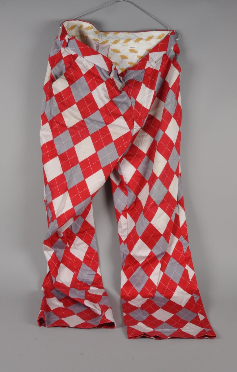 Rød-, hvit- og grårutete bukse.