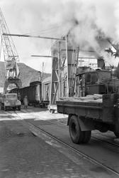 Omlasting av sekker fra jernbane til lastebiler på Ila pir