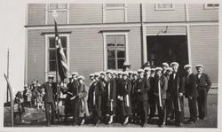 Sangkor med flagg utenfor en bygning.