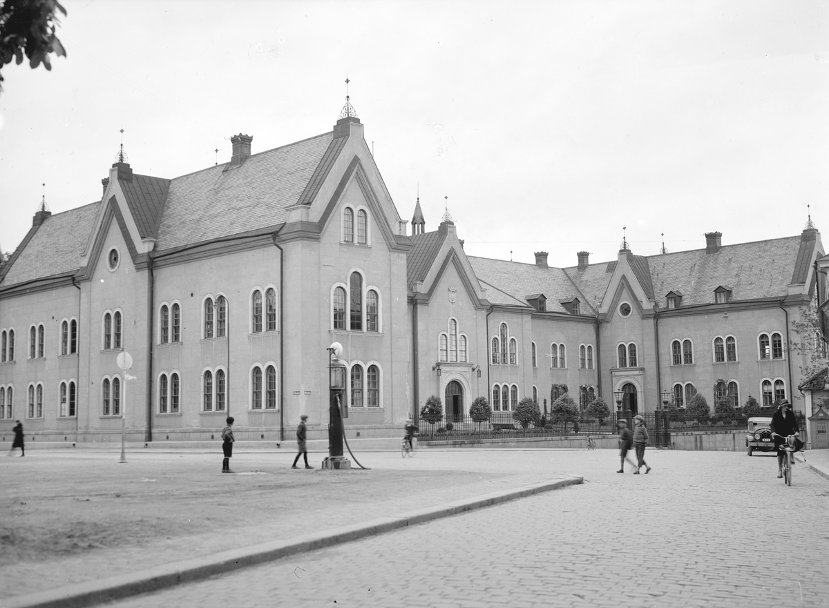 Vy mot Linköpings stadshus 1930. Byggnaden uppfördes ursprungligen att inrymma stadens läroverk. För ritningarna stod Johan Fredrik Åbom som skapade en byggnad i tydlig nygotisk stil. Huset var lärosäte under perioden 1864-1915. Efter interiöra ombyggnadsarbeten kom byggnaden från 1921 att tjäna som stadshus.