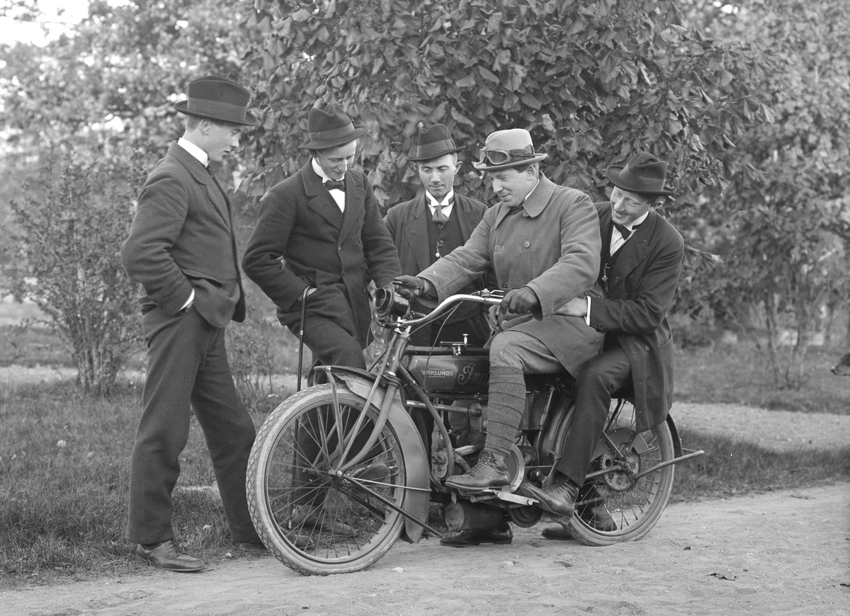 Edvin Karlsson visar stolt upp traktens första motorcykel för sina vänner. Märket är en Indian. Karlsson var i övrigt handlare i Svinhult under åren 1912-1927.