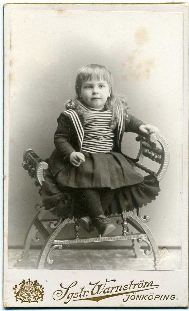 Kabinettsfotografi: okänd liten flicka sittande på en pall.