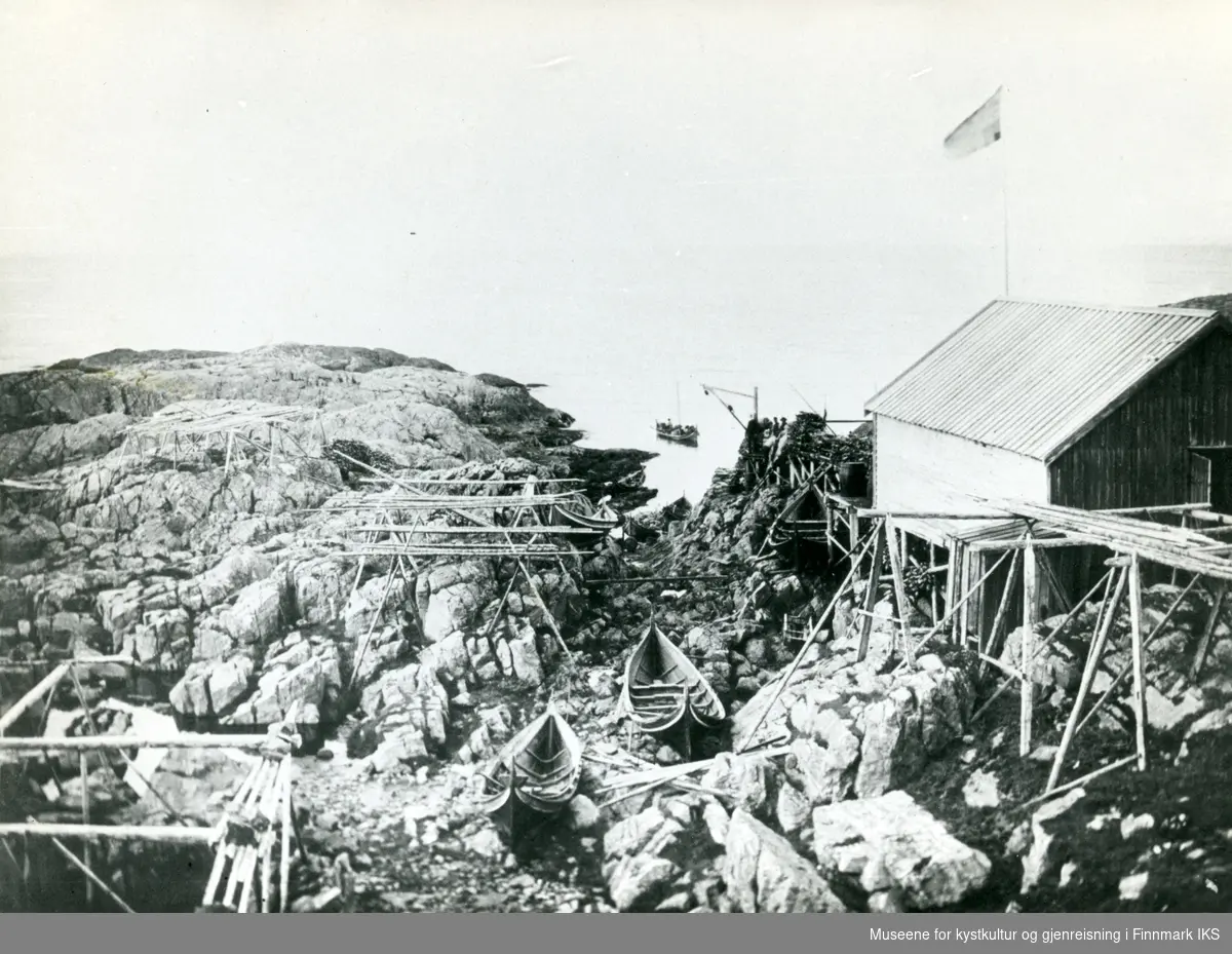 Helnes. Naust, fiskehjeller og nordlandsbåter på land og i sjøen. "Galge" på kaia. Ca. 1895.