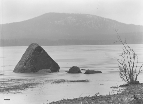 Dis och dimma över Hölesjöns is, Rengsjö 1951. Snart kommer två män och ett barn dit för att klubba lake intill strandkanten.
