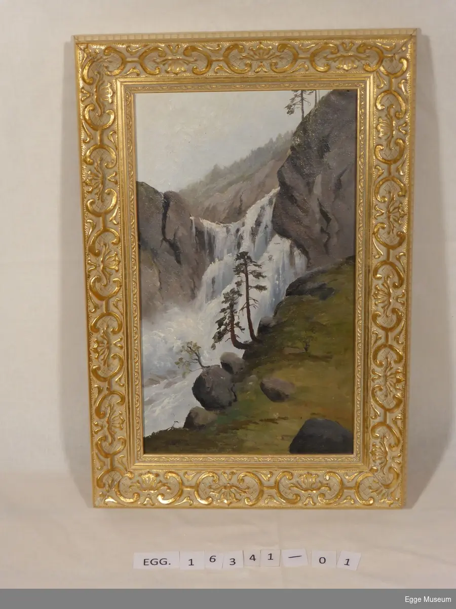 Maleriet viser et fossefall i Ringerike. Typisk norsk natur med fjell og bartrær ved fossen, og skog i bakgrunnen.