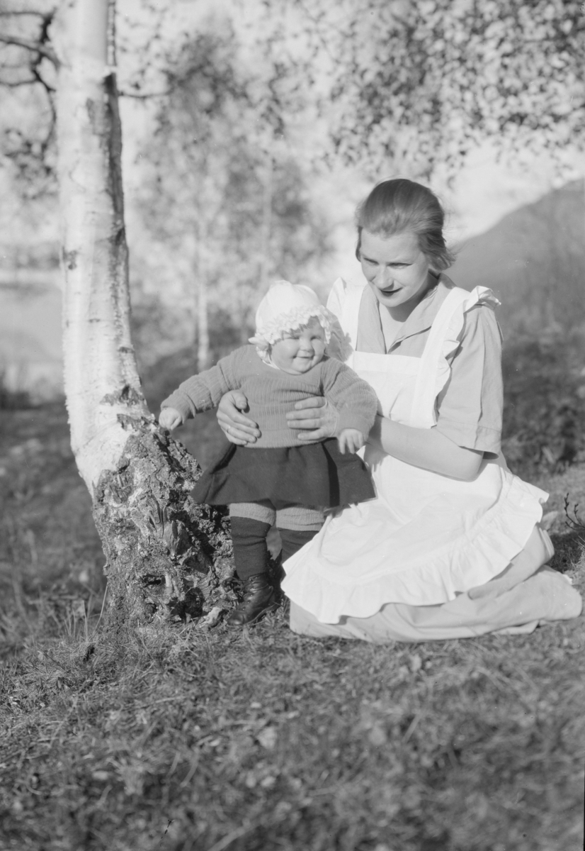 Gudrun Storvik med barnet Kari ved bjørkelegg