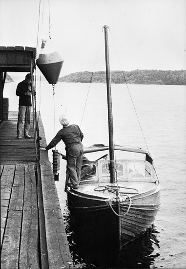 Enligt uppgift: "En av forskningsfartyget "Skageracks" utrangerade livbåtar, kallad "Nyvåg", togs till stationen 1961-62.
Från början öppen livbåt, ruffades för att användas vid mätningar. På bilden syns från vänster assistent Leif Nyberg och Oscar Åkermo. På bilden används en vattenmätare med boj".