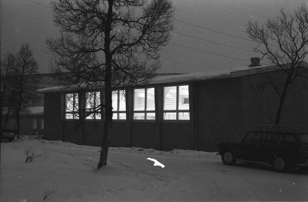 Gymnastikksal i Åsegarden leir. Bil i forgrunnen til høyre.