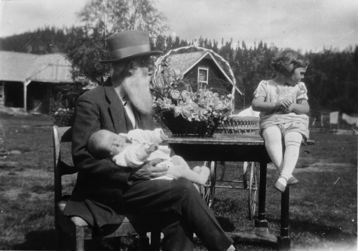 I. M. Egnund med stor blomsterkurv og to små barn. 