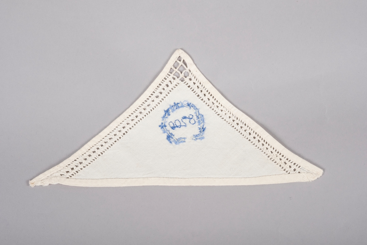 Hvit trekant lommetørkle med hullbroderier langs kanten og en brodert blå blomsterkrans rundt "8700", fangenummeret til Grete Wold.