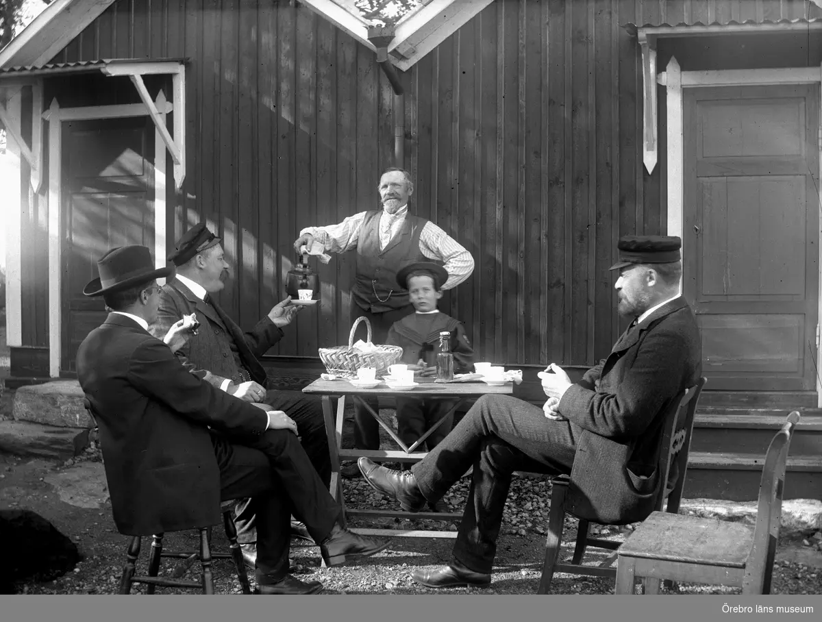 Lövön, Tisaren. 
Kaffedrickande män, Conrad Dahlqvist, Gottfrid Thermaenius, Wallin, Olle Thermaenius och Fredrik Thermaenius. I bakgrunden köket på Lövön.