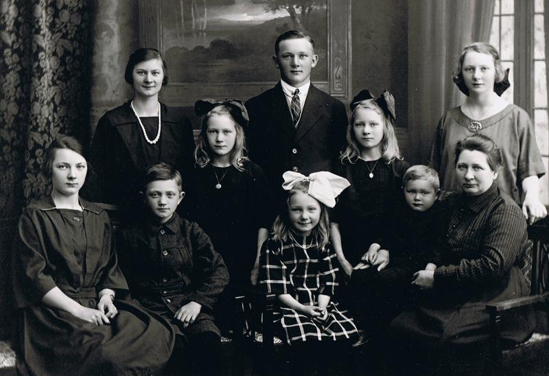Svart-hvitt bilde av ti personer, voksne og barn: Familien som ble igjen etter Ole Severin Olsen, som omkom i ei mineulykke ved Lillesand i 1920.