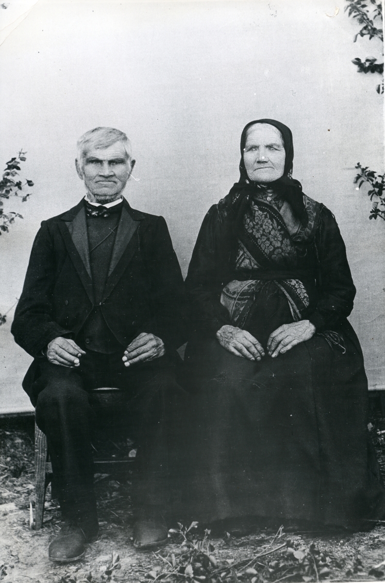 Portrett i helfigur av eldre mann og kvinne.