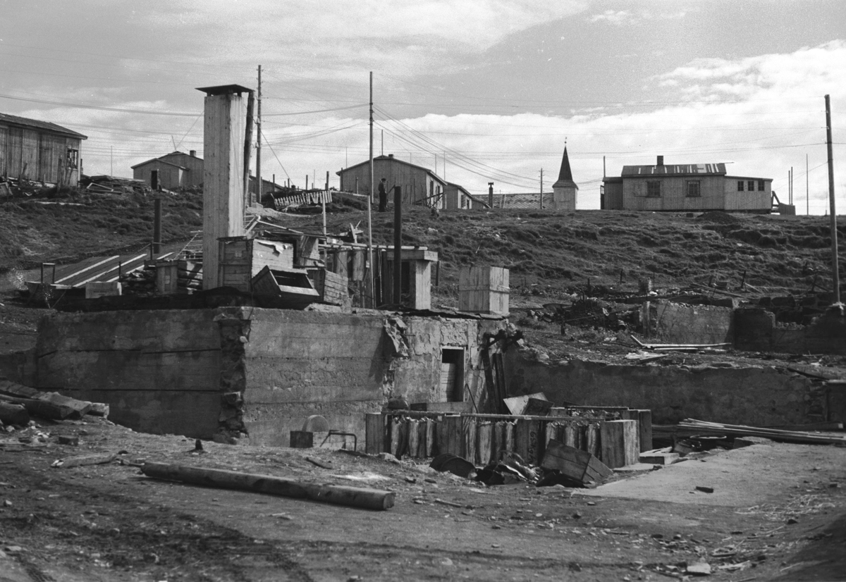Gjenreisning. Honningsvåg. Ruiner etter ødeleggelsen. Brakker og kirka i bakgrunnen. 1946/47.
