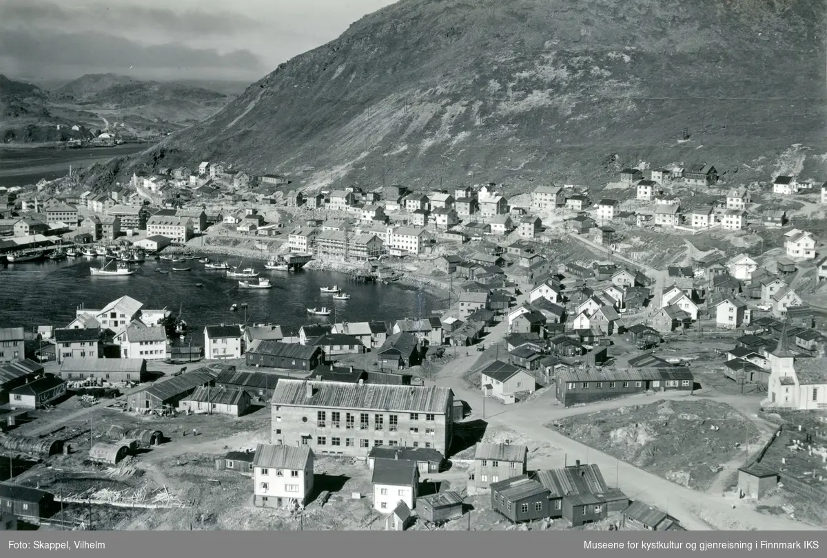 Flyfoto. Parti av Honningsvåg. Indre havn med gjenreisningsbebyggelse og brakker. Nederst til høyre Honningsvåg kirke. 31.07.1952