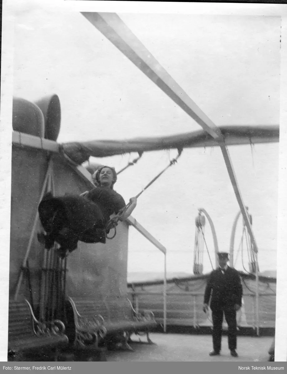 Kaptein Holst dytter dame som husker på dekk på båten over Atlanterhavet