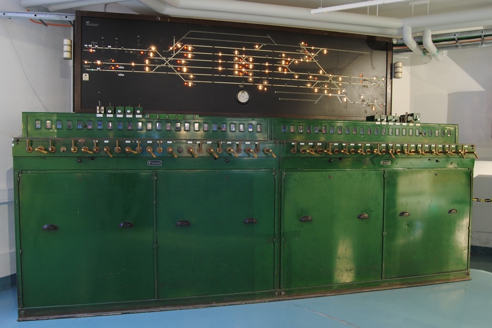 Elektriskt ställverk med elektriskt register. Enradigt ställverk. Grönt metallhölje. Består av två delar (Jvm 20212:1-2) med två luckor på framsidorna. Längst upp på höger sida sitter en grupp med knappar som fälles ut med en spärr. De är döpta Spår 1b-4b Avk. tågv. Dessutom finns en spak för "V1 fällbommar". På höger sida (:2) sitter dessutom ytterligare två knappar "45 h/vt" och "49t". Ställverket har 24 stycken fönster på var sida, d.v.s. 48 stycken tillsammans. Bakom dessa sitter blå och röda skyltar. På nästa etage sitter handtag, omväxlande små och stora, varav de stora har en tryckknapp som måste hållas inne då handtaget vrids åt vänster, men inte då det ska återställas. De stora handtagen är för växlar och spårspärr till växlar, och de små är för signaler. I mitten av en lucka på nedanför handtagen sitter en metallskylt "SIGNALBOLAGET STOCKHOLM SWEDEN". Luckan har två knoppar och går att öppna om två spärrar trycks in.