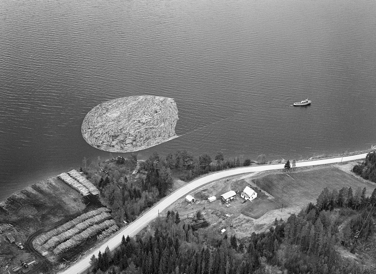 Flyfotografi, tatt over Fiskvikstøa i Ytre Rendalen, på Storsjøens vestside i 1981.  Vi ser hvordan riksveg 30 (her også kalt «Gamle kongeveg») slynget seg langs strandlinja. Mellom vegen og strandlinja, øverst til venstre i bildet, lå det en utislagsplass for tømmer som ble transportert til hovedvassdraget på lastebiler.  På vannspeilet ser vi en ringbom som ble slept sørover av tømmerslepebåten «M/S Storsjø».  Det tok vanligvis drøyt 30 timer å trekke en slik ringbom fra området ved Åsheim i nordenden av innsjøen til utløpet i elva Søndre Rena, om lag 36 kilometer lengre sør.  Med de store tømmermengdene som ble fløtet i 1950- og 60-åra ble det gjerne omkring 30 turer, og sesongen varte om lag to måneder.  Da dette fotografiet ble tatt, i 1981, kunne 10-12 ringbommer romme det tømmeret som skulle fløtes ut av Rendalen.  Virksomheten ble avviklet etter 1984-sesongen.