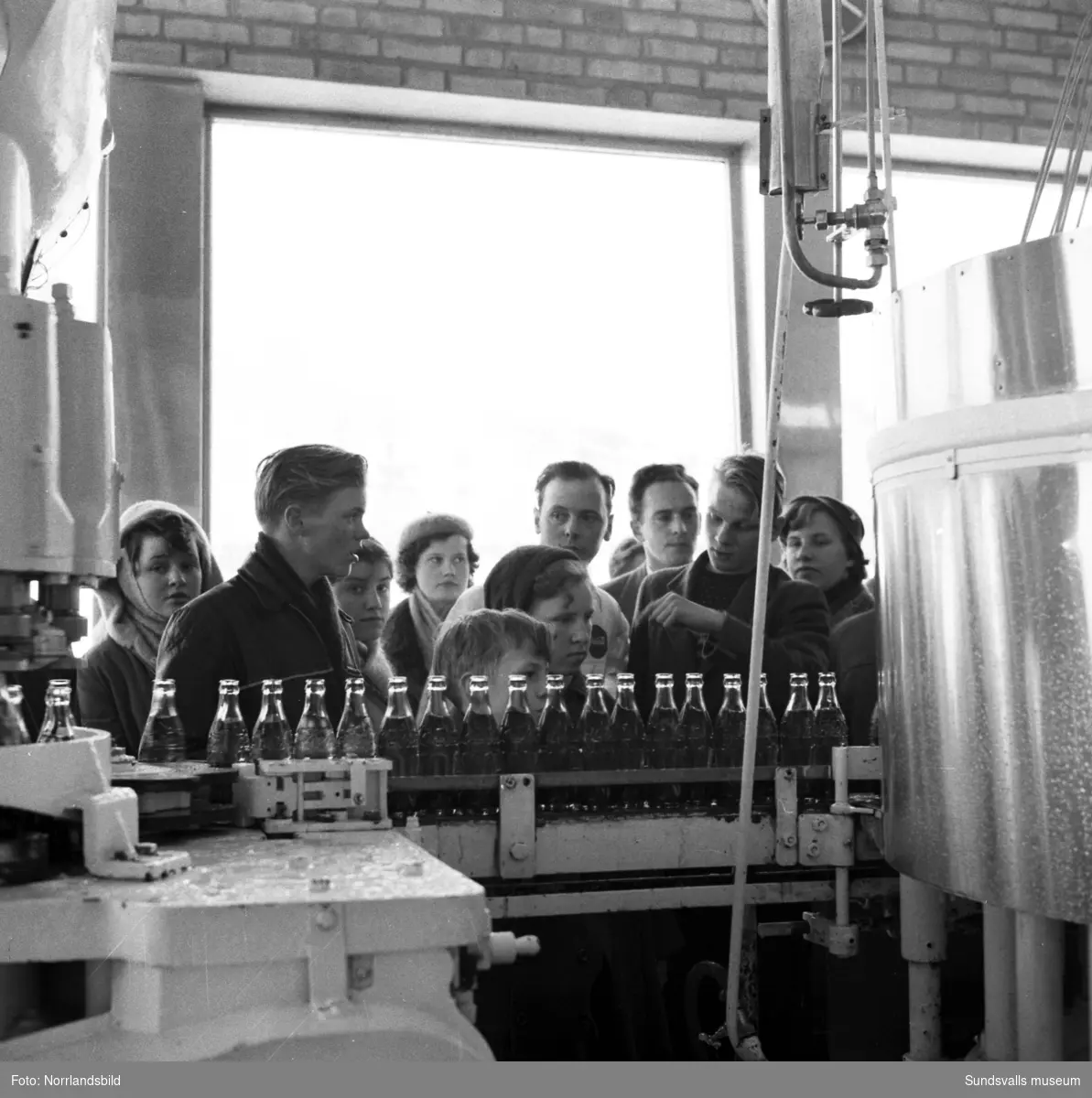 En skolklass är på studiebesök vid Coca-Cola-fabriken i Nacksta.