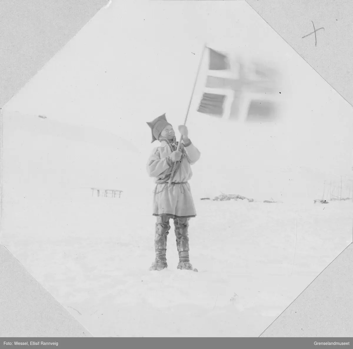 En samisk gutt vinker med det norske flagget.