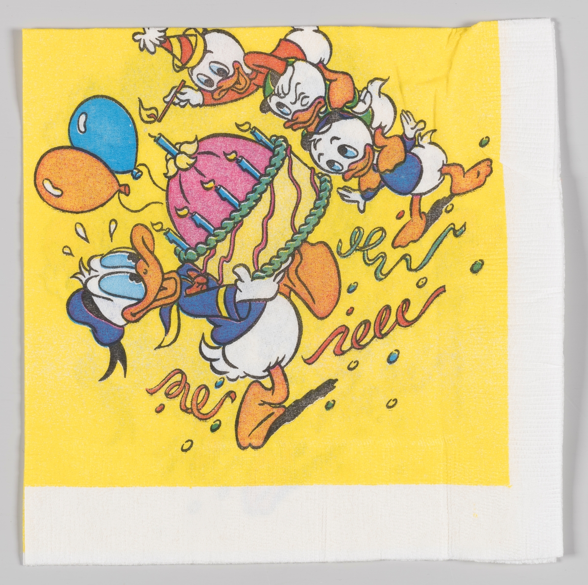 Donald Duck bærer en stor bursdagskake mens Ole, Dole og Doffen ser på