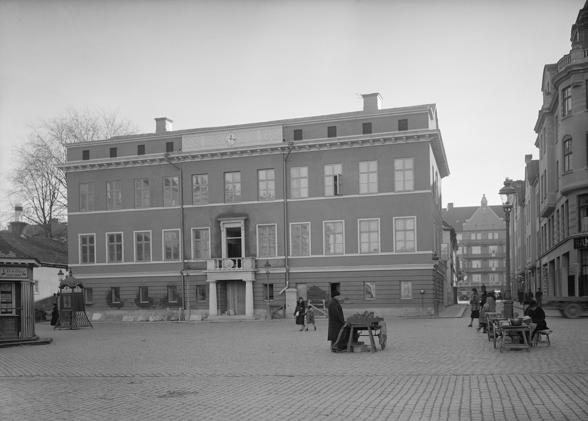 Linköpings före detta rådhus vid tiden för en genomgripande renovering som blivit klar 1927. Byggnaden var tänkt att ersätta det rådhus som blivit lågornas rov i den stora stadsbranden år 1700. En tilltänkt tomt utsågs men av ekonomiska skäl kom ingen byggnation igång. Istället kom landkamreraren Johan Olof Hertzman att förvärva tomten och lät uppföra stadens första nyantika byggnad som sin bostad. Fastigheten stod färdig 1799. Men redan 1803 ändrade sig borgarna som köpte ut Hertzman och byggnaden kunde tas i bruk som rådhus. Över tiden har fastigheten inrymt ett flertal verksamheter, främst i gatuplanet och i andra våningen. Borgmästare- och domprostboställe, bank och polisstation är några exempel.