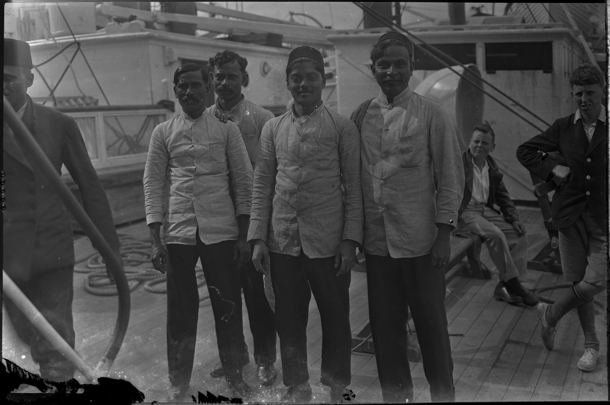 Mannskapet på "D/S Neuralia" er stilt opp for fotografen. Det også bilder tatt fra skipet av Vågen i Stavanger. Et bilde er av et korps med sekkepiper og trommer.