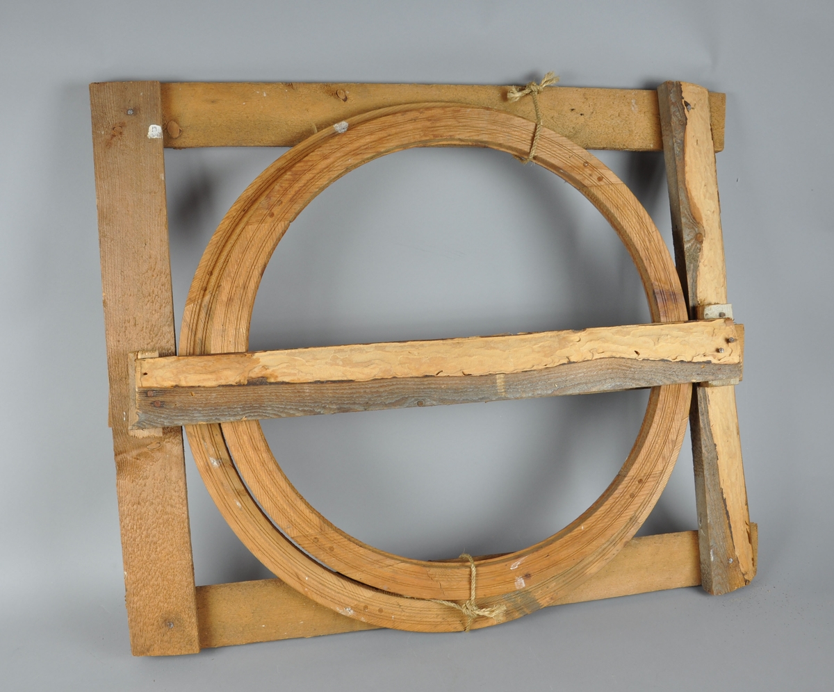 To hjul til dreiebenk, i ramme. Hjulene er satt sammen av 4 deler, naglet med treplugger. Treverket på rammen er i stor grad påvirket av skadedyr.