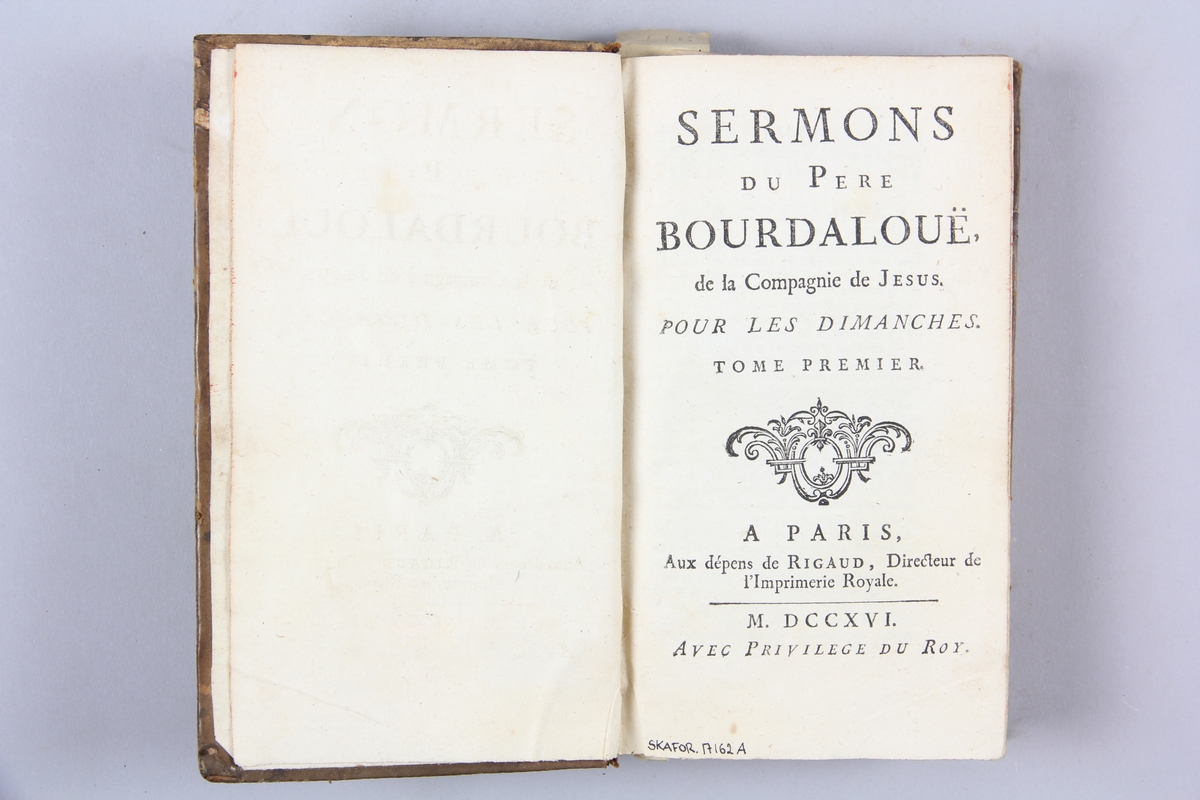 Bok, helfranskt band, "Sermons du Pere Bourdalouë" del 1, tryckt i Paris 1716. Skinnband med guldpräglad rygg med fem upphöjda bind. Titelfält med blindpressad titel, rödstänkt snitt. Etikett med samlingsnumret.