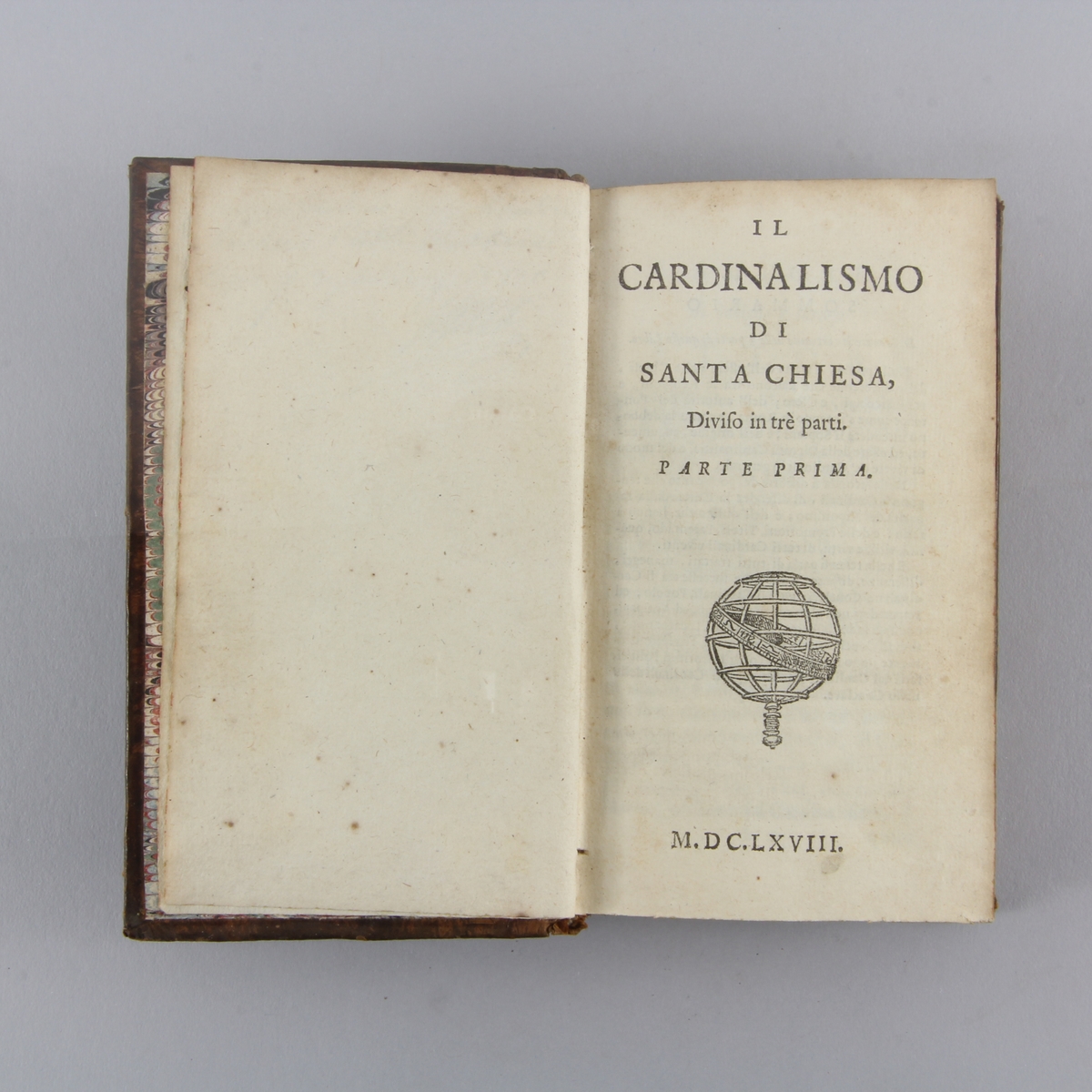 Bok, helfranskt band "Il cardinalismo di Santa Chiesa", del 1. Skinnband med guldpräglad rygg i fem upphöjda bind, marmorerat papper på pärmens insida. Rödstänkt skuret snitt.
Anteckning om förvärv.