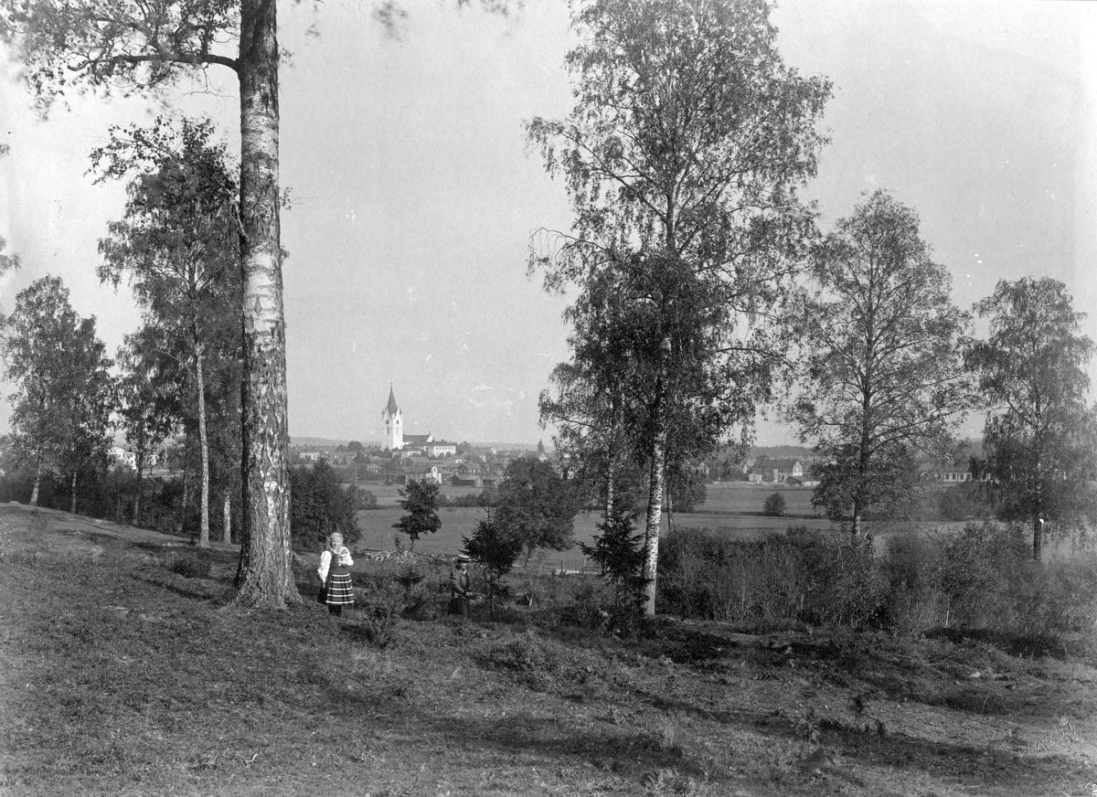 Vy från Hagby mot Nora. Kyrkan tornar upp sig i bakgrunden, 1907. Placerad i  (F4).
