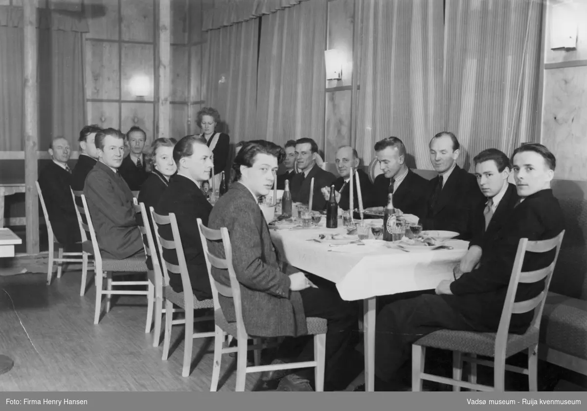 Menn og noen kvinner samlet rundt et festbord. Bjørn Sanness, Nils Fr. Jørgensen, Wara.G., Melsvik, Ingvald Ofstad, Bergljot Isaksen. Kilde; tekst bak på bildet (247_2)