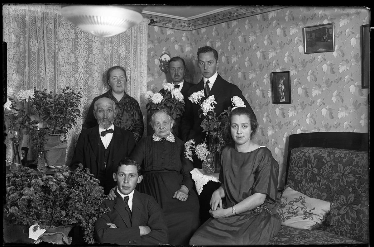 Familjeporträtt taget i samband med Svante och Ida Larssons guldbröllopsdag. Svante och Ida står längst bak tillsammans med deras ena son. På golvet sitter Hugo Larsson.