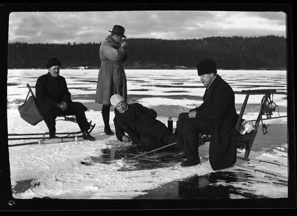 Fyra män tar en fikapaus på isen vid vinterfiske. Två av dem sitter på varsin spark, en ligger på isen och en står i bakgrunden och tänder en pipa. I fotografens egna anteckningar står det "Fiske. Olle, Claesson, Bredborg & Sven". Olle och Sven är bröderna Pettersson. Bredberg tolkad som Albin Bredberg.

Sven Pettersson sitter på sparken och hans bror Olle (1896-1985) ligger på isen.