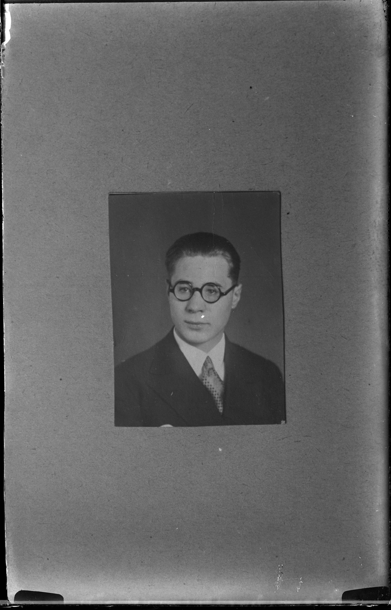 Reprofotografi av en porträttbild på en man i kostym och runda glasögon. I fotografens egna anteckningar står det "Repp. för fr. Vogel".