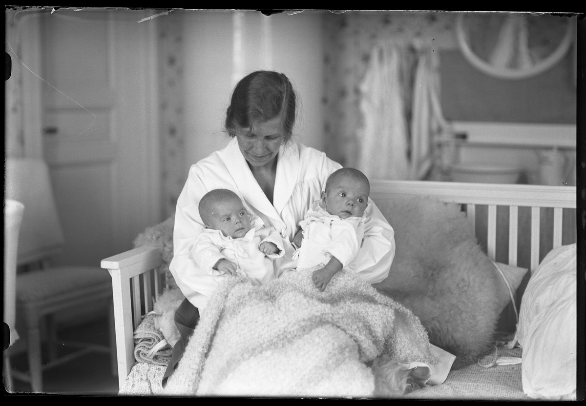 En kvinna sitter med två bäbisar, ett tvillingpar, i sitt knä. I fotografens egna anteckningar står det "Ing[enjör] Bergs tvillingar".