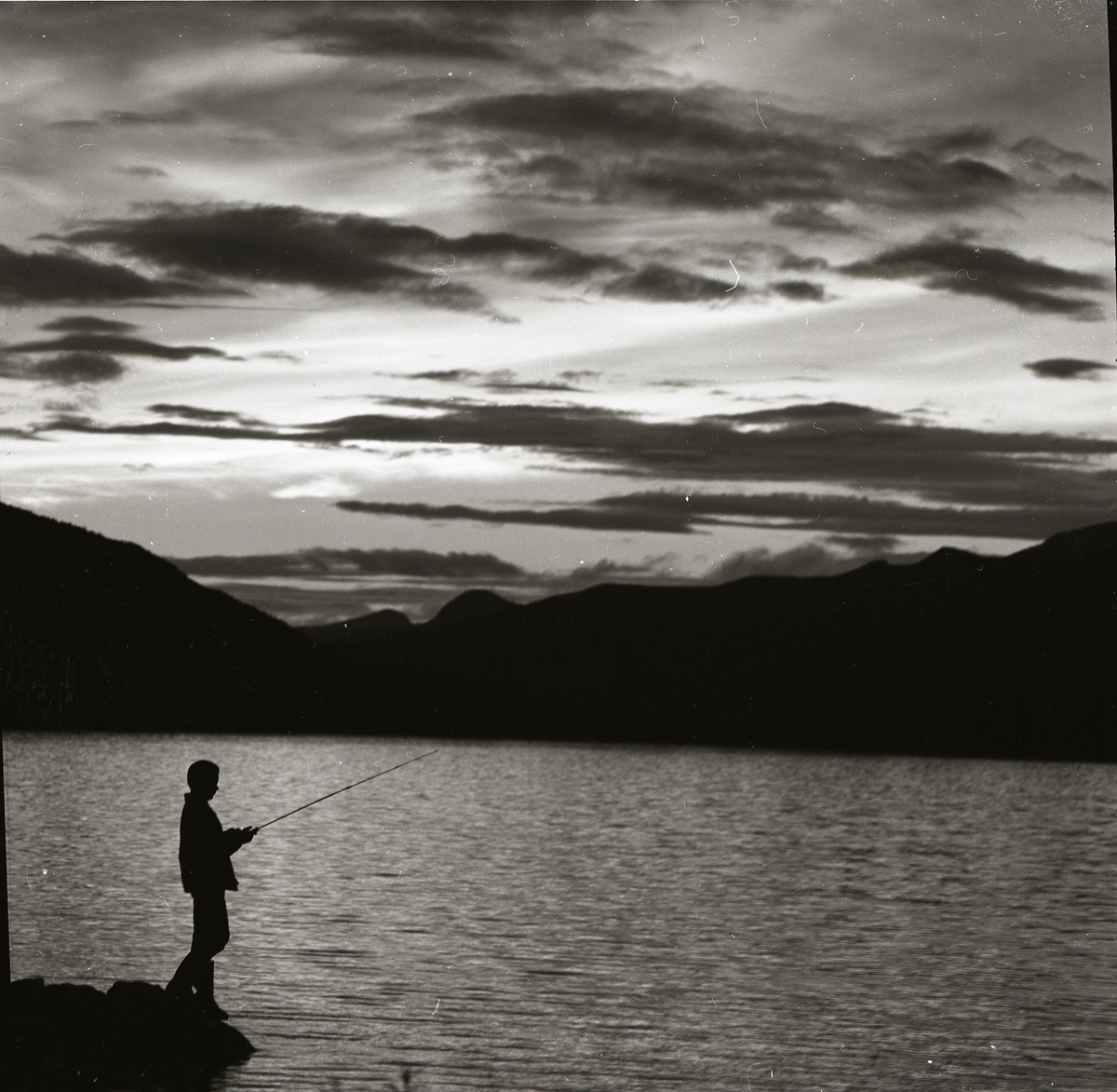 En pojke fiskar med kastspö en kväll vid Tänndalssjön 24 augusti 1960.