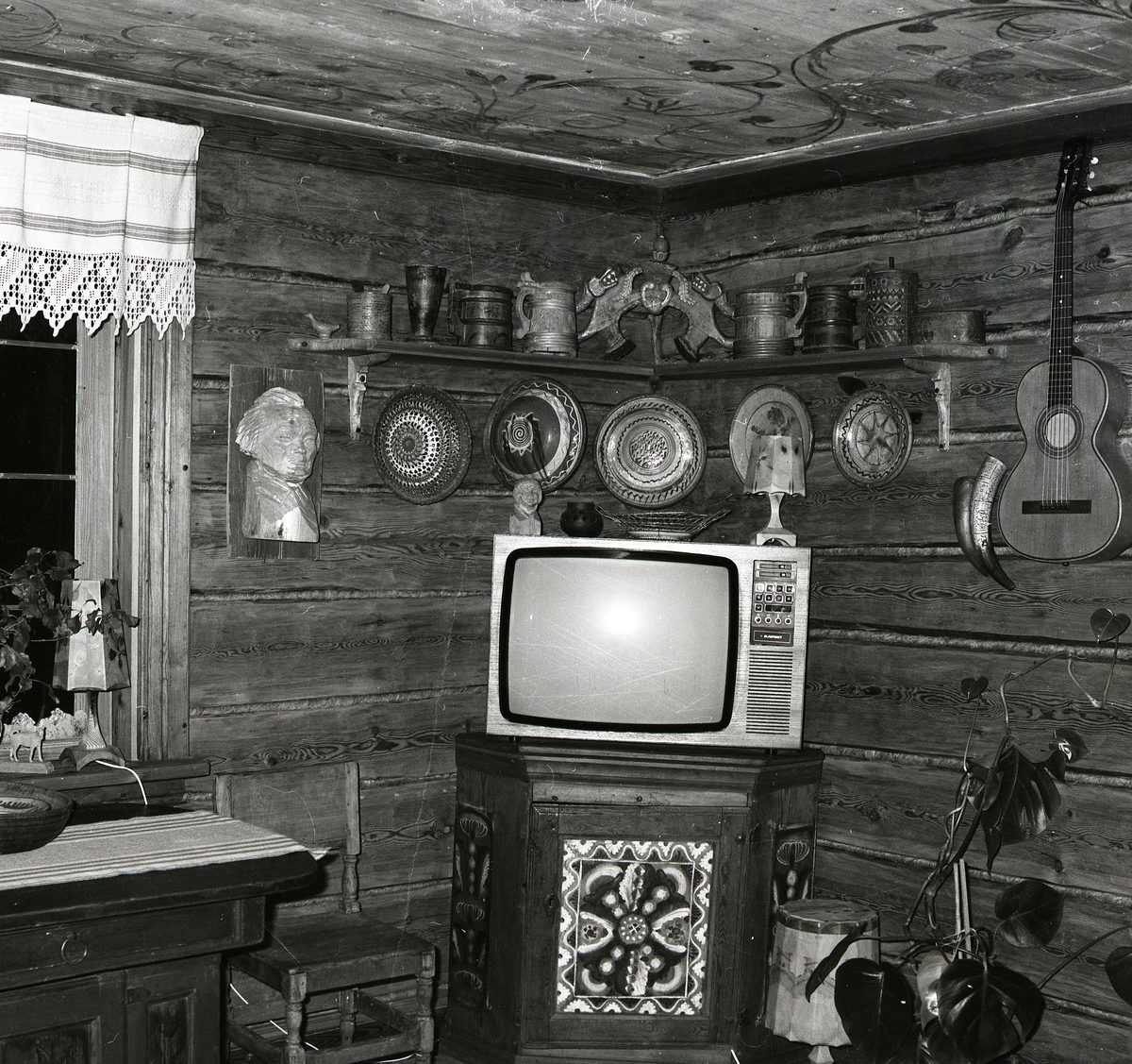 Interiör med hallen i gården Sunnanåker, 12 juni 1981. Det står en TV på ett skåp. På väggen hänger lerfat och en gitarr.