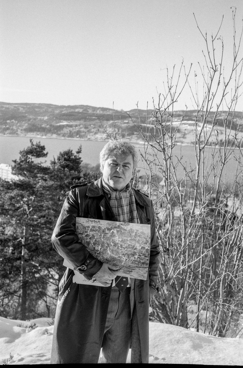 Kultursjef Olav Sandsmark i Frogn står på en kolle over Drøbak med plantegning/reguleringsplan under armen.
Frogn; mann; Plantegning; vinter
Drøbak frogn