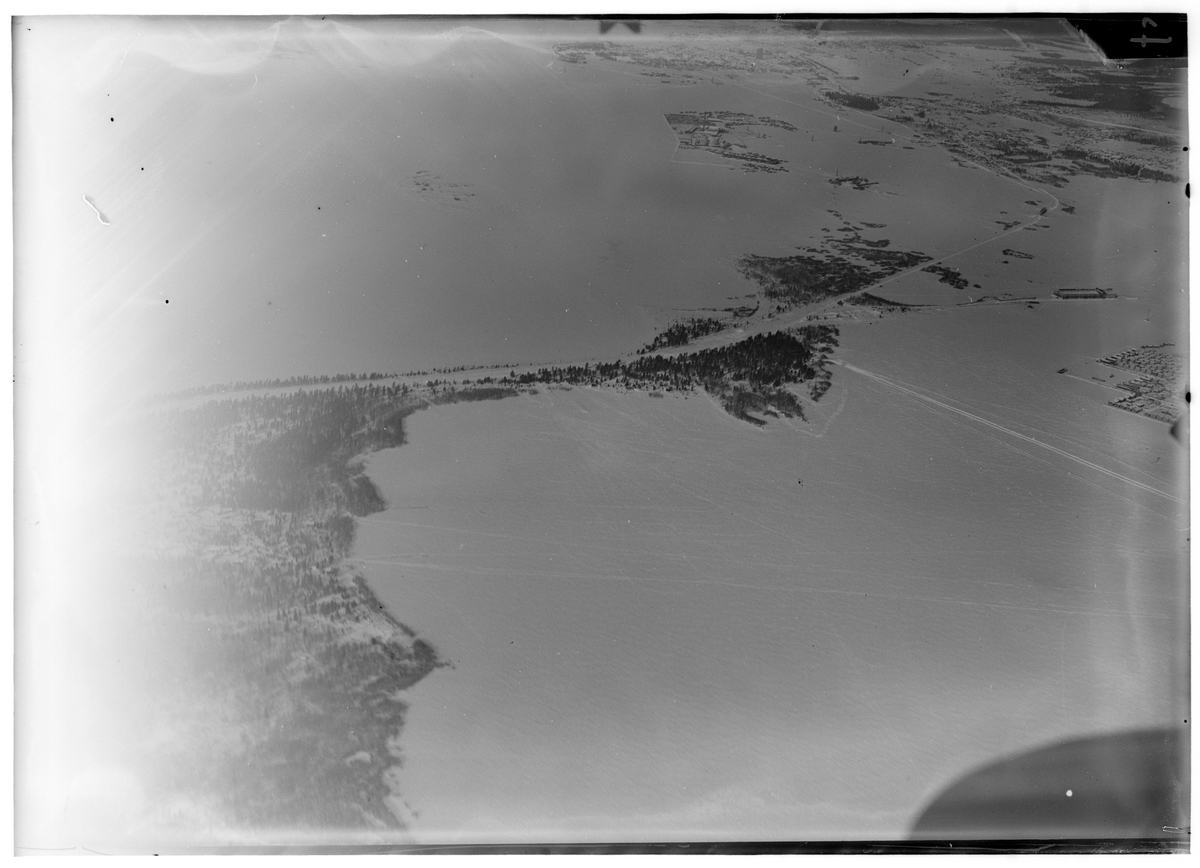 Flygfotografi från hög höjd av flygstationen på bakre basen i Veitsiluoto under finska vinterkriget 1940. Från F 19, Svenska frivilligkåren i Finland. I mitten av bild syns flygstationen, i bakgrunden syns Veitsiluoto samhälle.