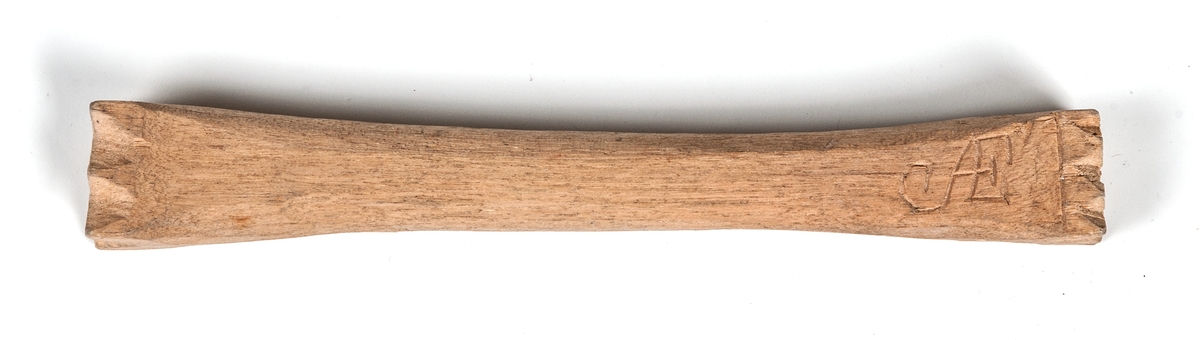 Messmörskrus av trä.
Två stycken stämpelytor skurna med uddsnitt.
Initialerna AE skurna längs långsidan.