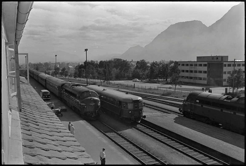 Torvet i Mosjøen 11.mars 1971. Biler er parkert både på torvet og i Strandgata. Jernbanestasjonen. Aluminiumsverket.