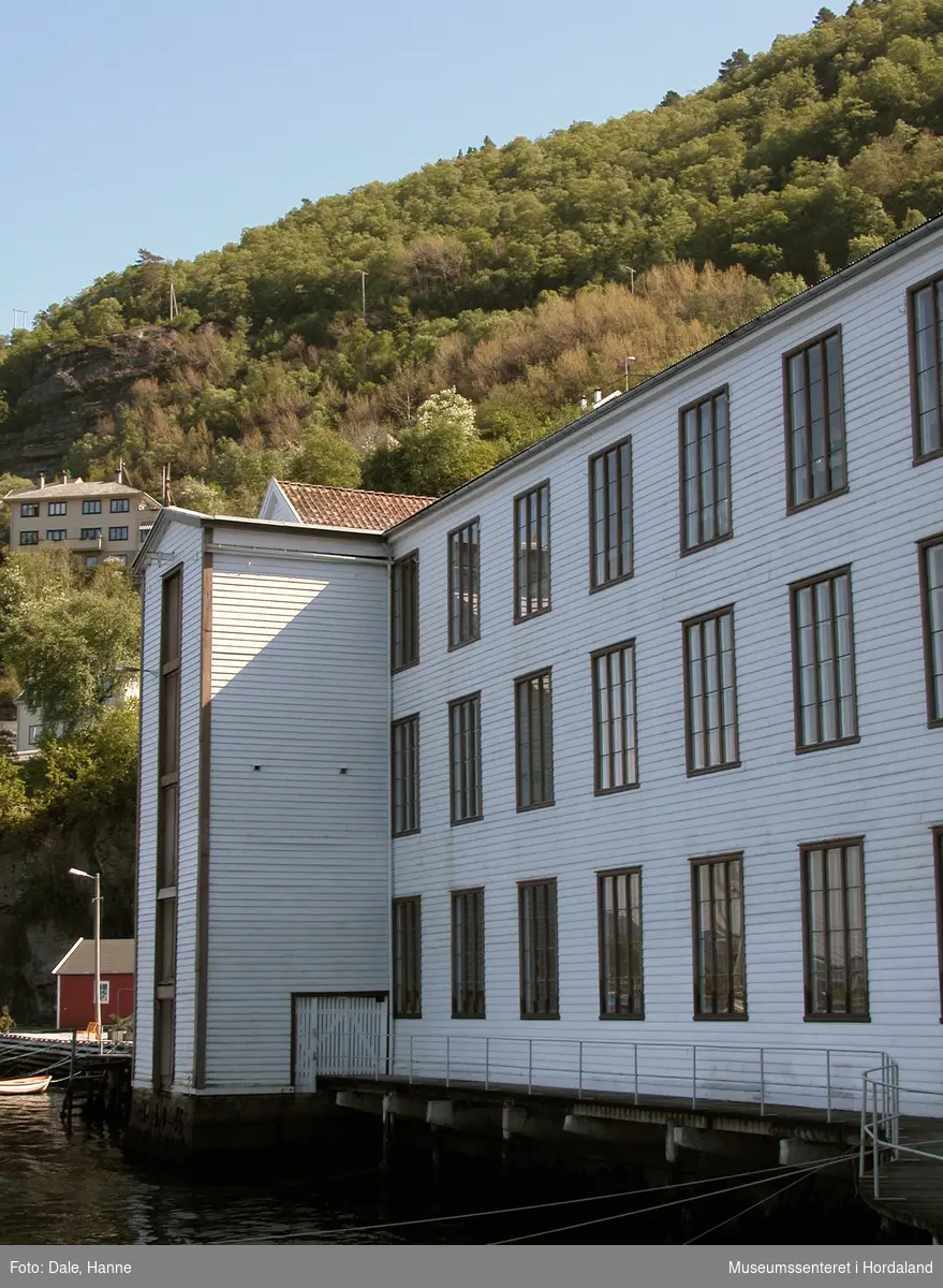Del av produksjonslokala til Salhus Tricotagefabrik (1859-1989) bygd i 1934. Tilbygg til produksjonslokala brukt til garnlager.