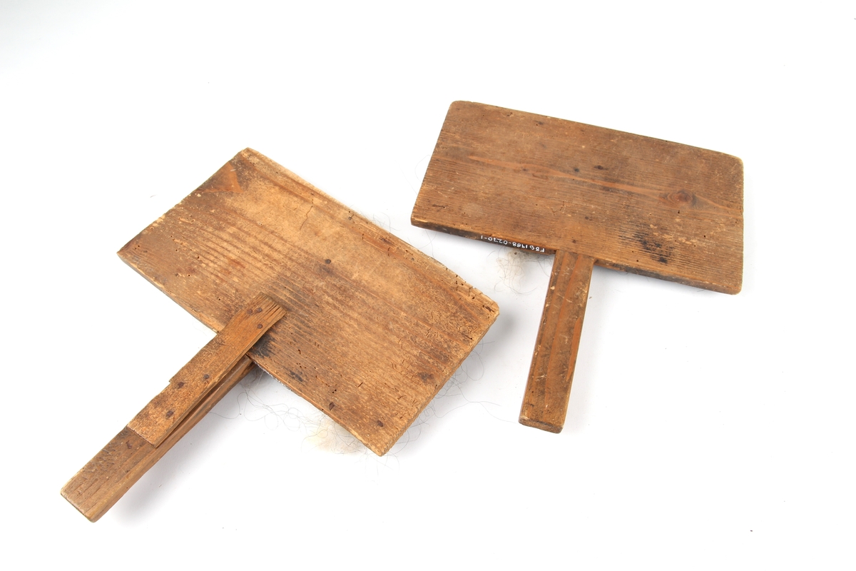 To håndkarder som består av en plate med håndtak. Platen er dekket av tettsittende nåler i et lag av lær.