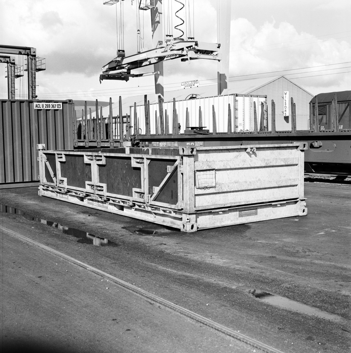 Containerflak. I bakgrunden syns godsvagnar och en containertravers.